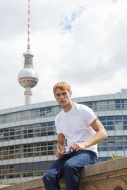 Man sitting on a ledge with the Berlin TV tower in the background