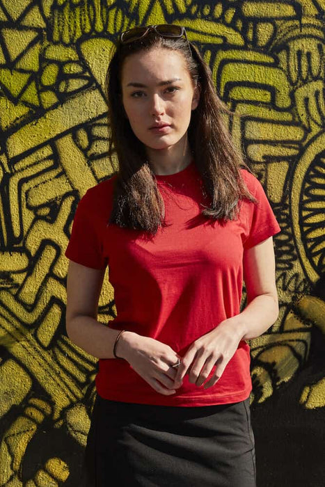 Person wearing a red shirt standing in front of a textured yellow wall